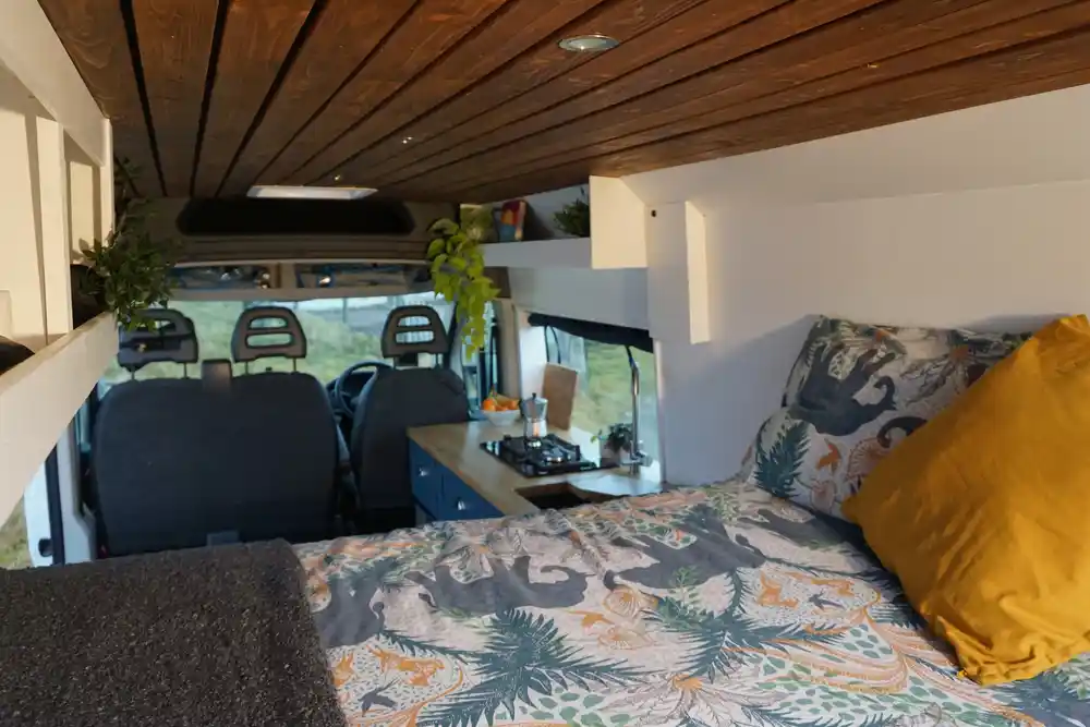 Sprinter campervan interior view from bed looking towards cab and kitchen